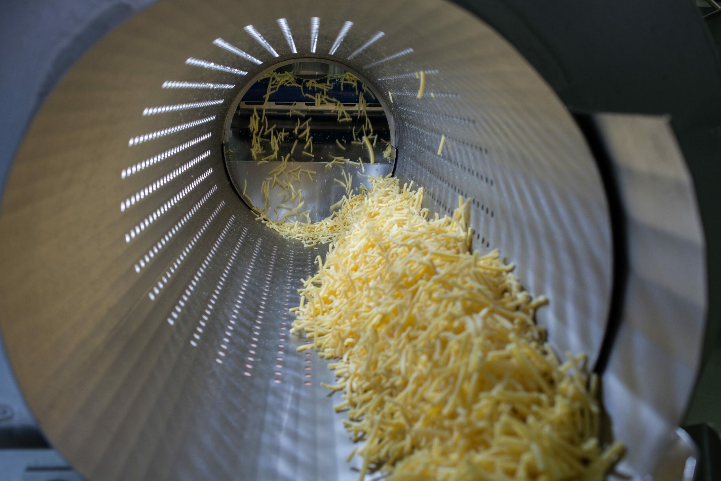 Der Reibkäse entsteht aus großen Käseblöcken, die vorher und nachher gewogen werden. (Bild: Frischpack GmbH)